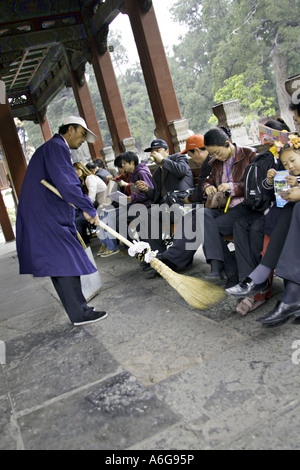 CHINA Peking chinesische Sommerpalast Park Arbeiter fegen den Boden der langen Galerie unter den Füßen der Touristen, die dort ruhen Stockfoto