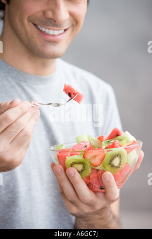 Mann isst einen Obstsalat Stockfoto