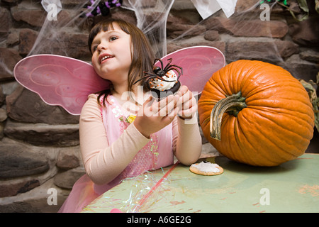 Mädchen mit einer Spinne-Torte Stockfoto