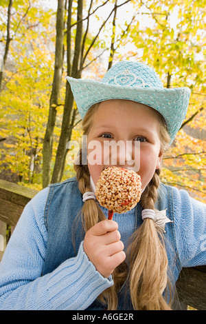 Mädchen einen Glasierter Apfel essen Stockfoto