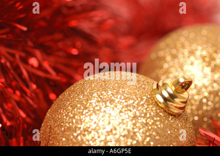 Goldene Weihnachtskugeln und rote Lametta aus nächster Nähe Stockfoto