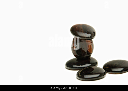 Schwarze glatte Kieselsteine auf weißem Hintergrund Zen Stockfoto