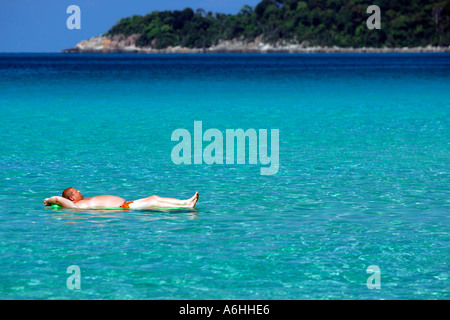 Großer Mann schwimmt auf Luftmatratze Perhentian Kecil Malaysia Stockfoto
