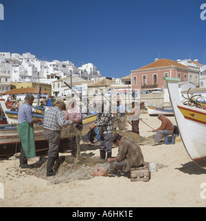 Portugal Algarve Albufeira Fischerstrand Männer ausbessern Netze Stockfoto