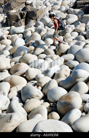 Frau zu Fuß auf Pebble Beach in Cornwall, England, Vereinigtes Königreich Stockfoto