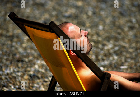 Mann Alsleep im Liegestuhl am Strand von Aldeburgh, Suffolk, UK. Stockfoto