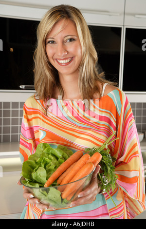 junge Frau präsentiert Salatzutaten Stockfoto