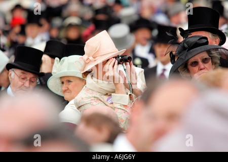 Frau am Royal Ascot Pferderennen, Blick durch ein Fernglas, York, Großbritannien Stockfoto