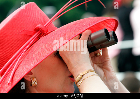 Frau, die durch ein Fernglas bei Royal Ascot Pferderennen, York, Großbritannien Stockfoto