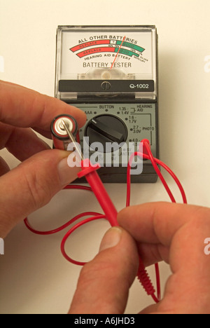 AA-Batterie auf einem Batterietester testen Stockfoto