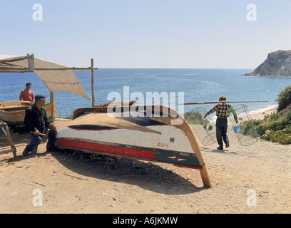 Portugal die Algarve; Männer Instandsetzung Fischerboot und Fischer mit Hummer Töpfen bei Burgau Stockfoto