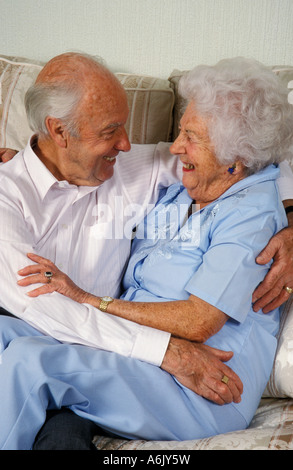 ältere Liebespaar kuscheln und Lachen auf sofa Stockfoto