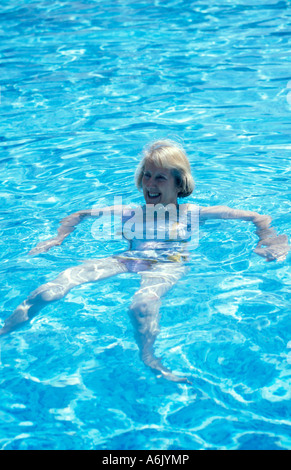 Reife Frau am Rücken im Außenpool schwimmen Stockfoto