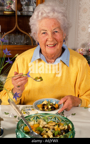 Porträt glückliche gesunde ältere Frau am Tisch essen gesunde Mahlzeit Stockfoto