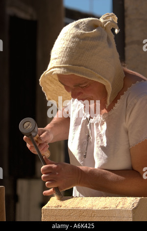 Französische Frau Steinmetzerin, Steinbildhauerin in französischer Zeit Kostüm Schnitzerei Stein mit Handwerkzeugen auf mittelalterlichen Festival, Aquitaine Südwesten Frankreich eu Stockfoto