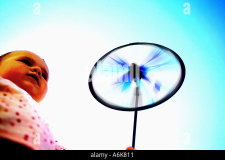wenig baby hält einen Windwheel in den Himmel Stockfoto