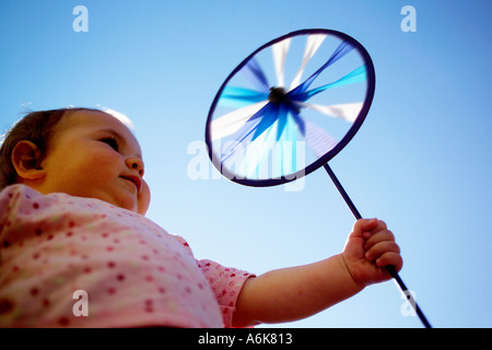 wenig baby hält einen Windwheel in den Himmel Stockfoto
