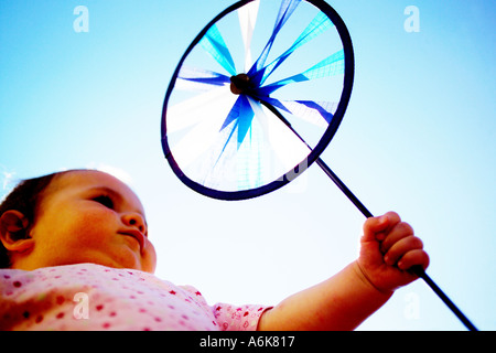 wenig baby hält einen Windwheel in den Himmel Stockfoto