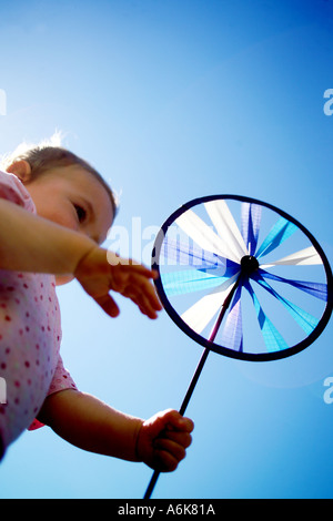 wenig baby hält einen Windwheel in den Himmel Stockfoto