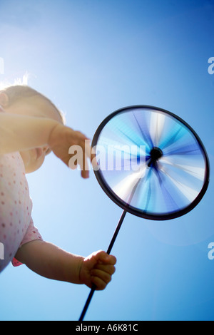 wenig baby hält einen Windwheel in den Himmel Stockfoto