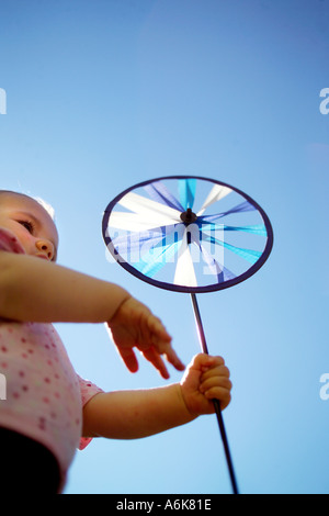 wenig baby hält einen Windwheel in den Himmel Stockfoto