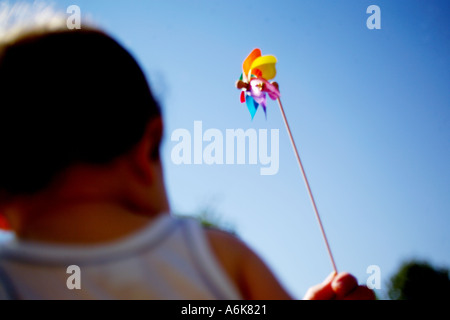 wenig baby hält einen Windwheel in den Himmel Stockfoto