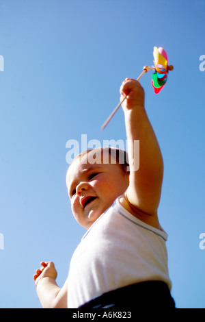 wenig baby hält einen Windwheel in den Himmel Stockfoto