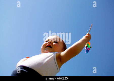 wenig baby hält einen Windwheel in den Himmel Stockfoto