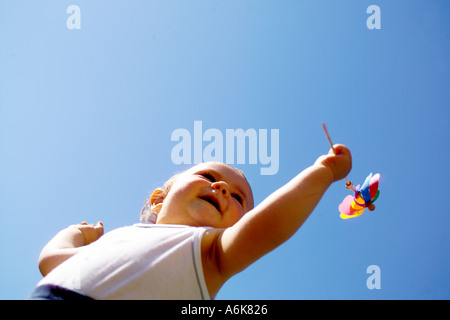 wenig baby hält einen Windwheel in den Himmel Stockfoto