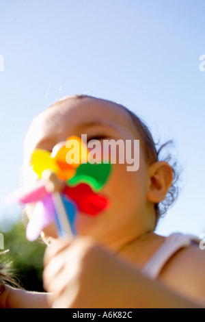 wenig baby hält einen Windwheel in den Himmel Stockfoto