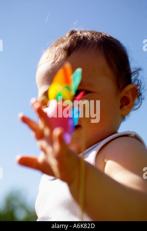 wenig baby hält einen Windwheel in den Himmel Stockfoto