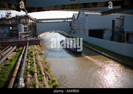 Schmale Boot durchläuft die Lostock chemische Werke auf dem Trent Mersey Kanal in der Nähe von Northwich Cheshire Stockfoto