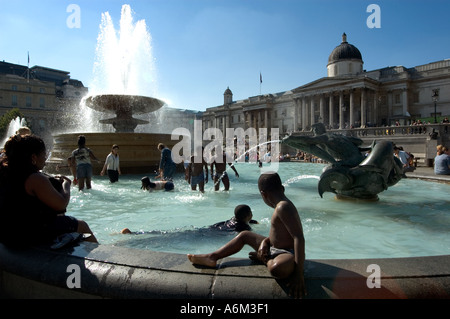 Kleinkinder, die Abkühlung im Brunnen während der Hitzewelle am Trafalgar Square in Central London Stockfoto