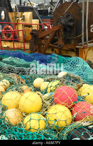 Bunten Fischernetze und schwimmt auf der Anklagebank neben einem Fischerboot in Dingle Hafen County Kerry Irland Stockfoto