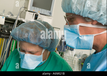 Ärzte und Krankenschwestern versammeln sich um OP-Tisch während der Operation Stockfoto