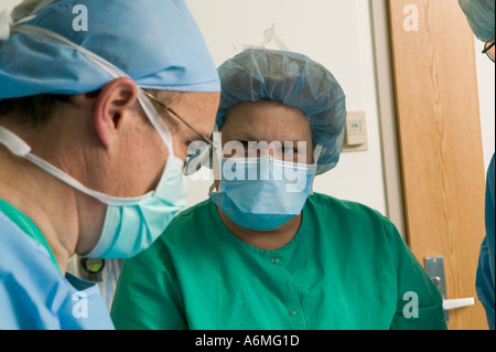 Ärzte und Krankenschwestern versammeln sich um OP-Tisch während der Operation Stockfoto