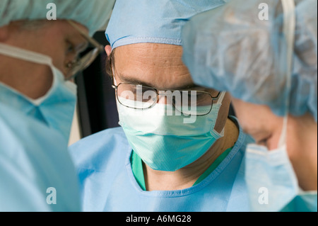 Ärzte und Krankenschwestern versammeln sich um OP-Tisch während der Operation Stockfoto