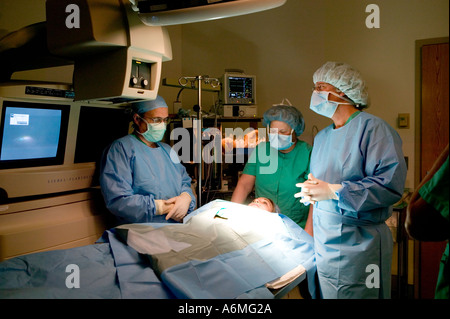 Ärzte und Krankenschwestern versammeln sich um OP-Tisch während der Operation Stockfoto