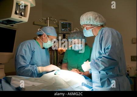 Ärzte und Krankenschwestern versammeln sich um OP-Tisch während der Operation Stockfoto