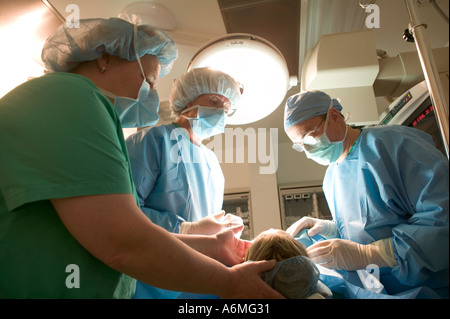 Ärzte und Krankenschwestern versammeln sich um OP-Tisch während der Operation Stockfoto