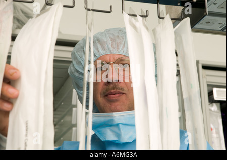 Krankenpfleger erreicht für Sterilgut im OP-Saal Stockfoto
