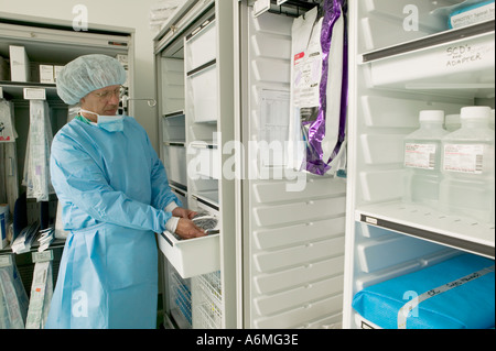 Krankenpfleger erreicht für Sterilgut im OP-Saal Stockfoto
