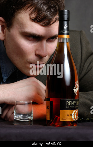 Betrunkener Mann mit einer Flasche Cognac Stockfoto