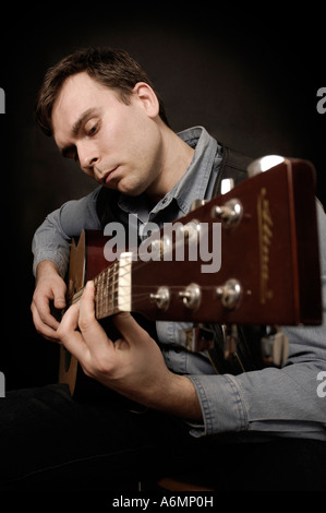 Mann-Musiker spielt akustische Gitarre Stockfoto