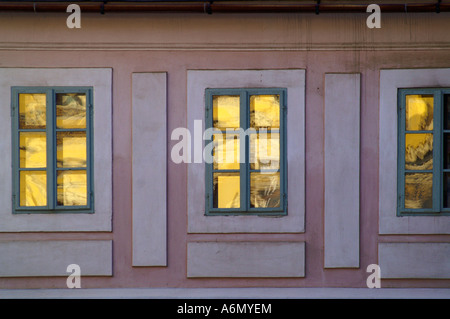 Drei Fenster reflektiert Sonne auf historische Fassade des Hauses in Banska Stiavnica, Slowakei Stockfoto