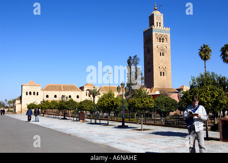 männliche englische Tourist sucht ein Tour Guide Buch vor der Koutoubia Koutoubia Minarett in Marrakesch, Marokko Stockfoto