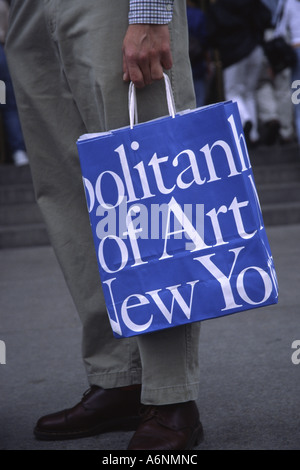 Souvenir-Einkaufstasche, die von Besuchern vor dem Metropolitan Museum of Art New York City gehalten wird Stockfoto