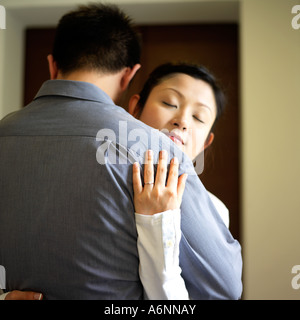 Junge Frau trägt Verlobungsring, umarmen Mann Stockfoto
