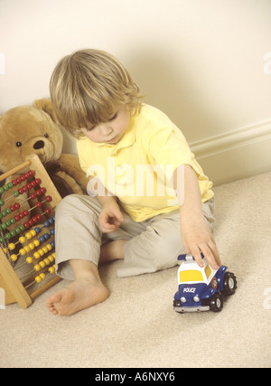 Kleiner Junge spielt mit Spielzeug aus Plastik Einsatzfahrzeuge Stockfoto