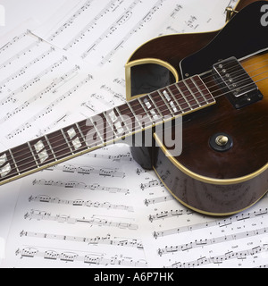 Eine Gitarre jazz Hohlkörper sitzt oben auf Noten Stockfoto